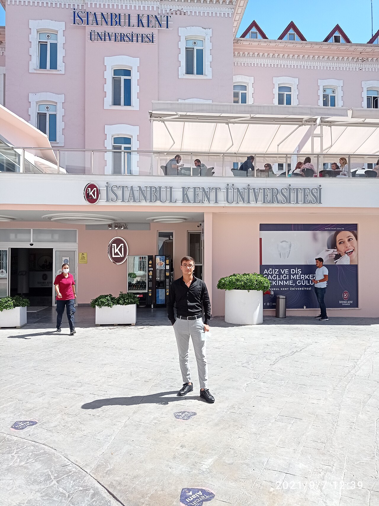 ورودی حیاط ساختمان پردیس تاریخی صورتیرنگ Istanbul Kent University در Beyoğlu، با تابلوی «İSTANBUL KENT ÜNİVERSİTESİ».
